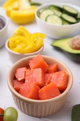 Ingredients for poke bowl on white textured table, closeup