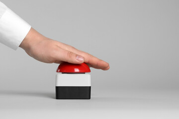 Man pressing red button of nuclear weapon on light gray background, closeup with space for text....