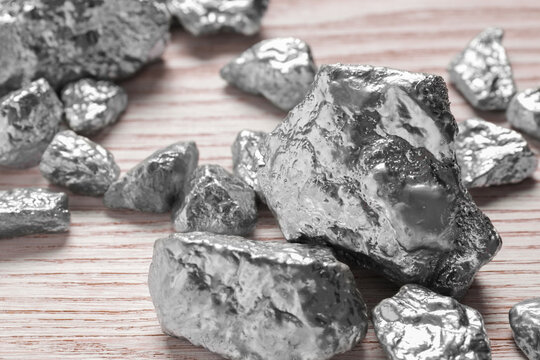 Pile of silver nuggets on white wooden table, closeup