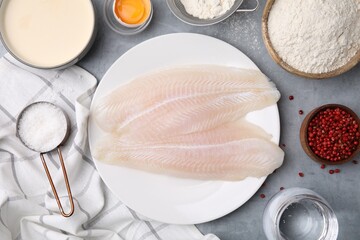 Different ingredients for soda water batter and raw fish fillet on grey table, flat lay