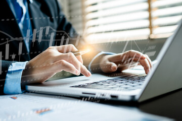 Business people using a laptop to analyze the stock market, graphs, charts, and data display a stock graph visual screen,.modern technology for presentations related to finance and investing.