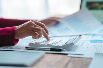 Close up bookkeepers working with balance sheet to analyze problems and find solutions to bringing develop business organization and company's stock market system. Using calculator