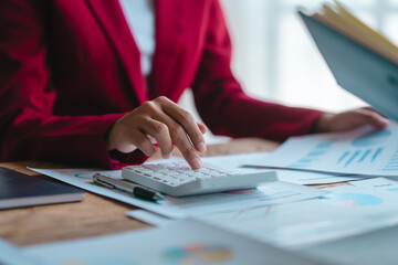 Close up bookkeepers working with balance sheet to analyze problems and find solutions to bringing develop business organization and company's stock market system. Using calculator