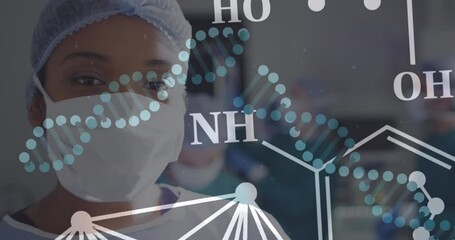 Animation of dna strands and african american female surgeon in face mask - Powered by Adobe