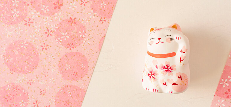 Background material to celebrate spring. Sakura Japanese paper and cat brings luck. Spring, passing, announcement of results, admission, joining a company, etc. 春を祝う背景素材。桜の和紙と招き猫。春、合格発表、入学式、入社式、イベントなど