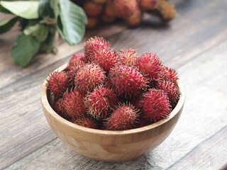 Rambutan fruits in a wooden bowl. Rambutan is tropical and asian fruits, sweet and Delicious, healthy food contain vitamin and nutrition