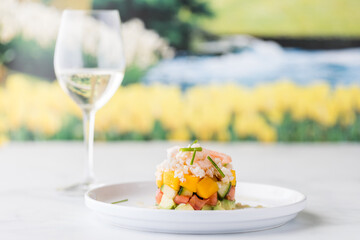 A close up of a homemade shrimp and crab stack salad garnished with chives.