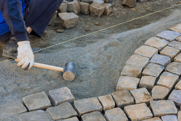 Paving of street with granite stones was laborious task that required skilled workers to use...