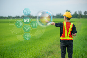 The engineering worker wearing hard hat and protection vest raised their arm and pointed at the sky to show the optimal position for a 5G antenna installation.