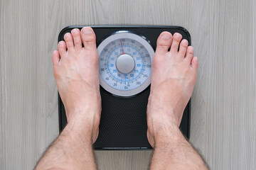 Legs of men standing on scales weight. Concept of health and weight loss.