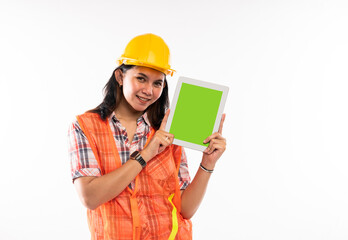 a female architect in safety waistcoat standing with smile and showing the digital tablet with green screen on isolated background