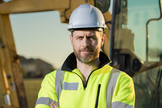 Worker with bulldozer on site construction. Man excavator worker. Construction driver worker with excavator on the background. Construction worker with tractor or construction vehicle at building.