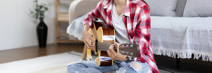Woman practicing or learning to play guitar and practice using his fingers to hold guitar chords...