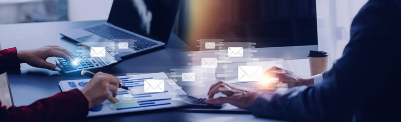 Businessman hands using Laptop typing on keyboard and surfing the internet on office table with email icon, email marketing concept, send e-mail or news letter, online working internet network.