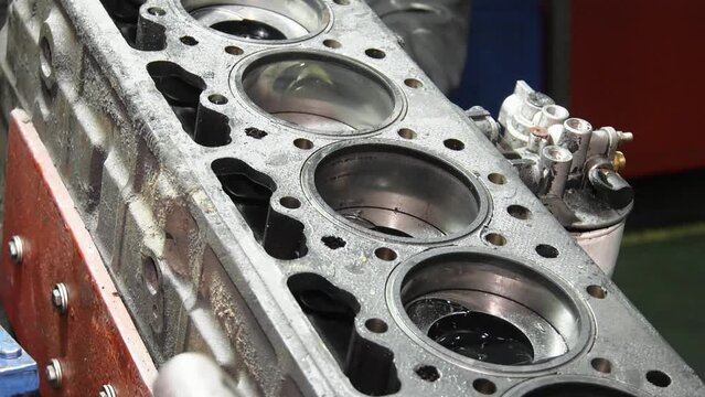 Repair of engine head and valves. Disassembled machine engine at modern auto service.  Auto mechanic working on car engine in mechanics garage. the cylinder block.
