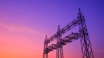 Silhouette low angle view of high voltage steel electric pylons that are not connected to electric...