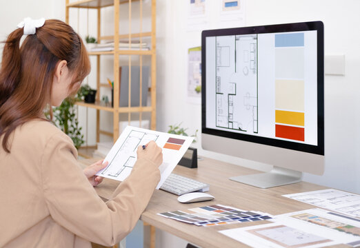 Thoughtful interior designer looking at computer screen while working at desk in office, Design develop for new interior project. Architecture renovation style design graphic.