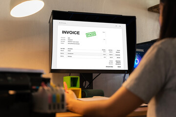 Business Invoice Tax Management. Accountant Using Monitor, studying financial business documents at...