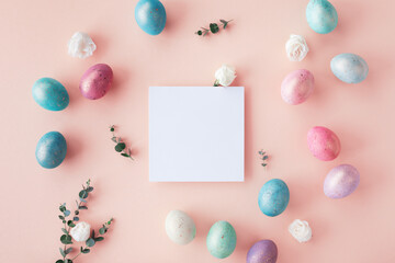 Easter spring concept. Top view photo of empty square blank, colorful eggs and flowers on pastel table.