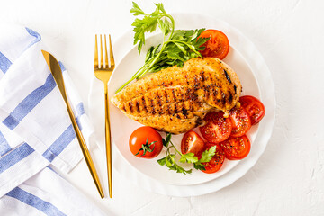 a large juicy piece of grilled chicken breast fillet without oil. delicious healthy food. top view. white table, cutlery.