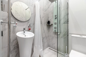 Modern renovated bathroom with a white shell, mirror and marble wall