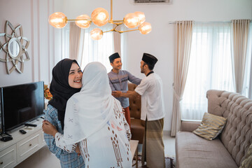 Fototapeta premium muslim friends embracing during visiting family eid celebration at home