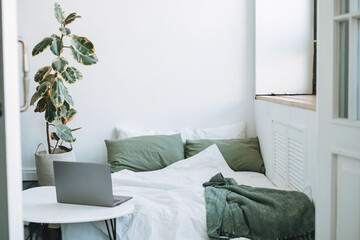Opened laptop in scandinavian modern cozy bright interior in bedroom at home