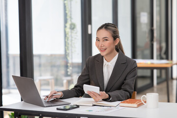 ฺAsia Businesswoman sitting and working using laptop to chat with customers online in office