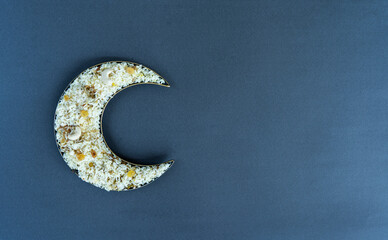 Iftar food in a crescent moon shape plate with copy space © forclick