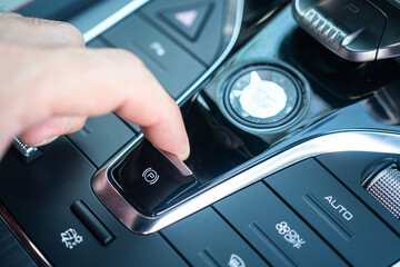 Action of a driver is pulling the electric parking brake switch to activate the brake during...