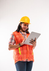 a beautiful architect with hardhat standing and looking at the digital tablet at her hand on isolated background