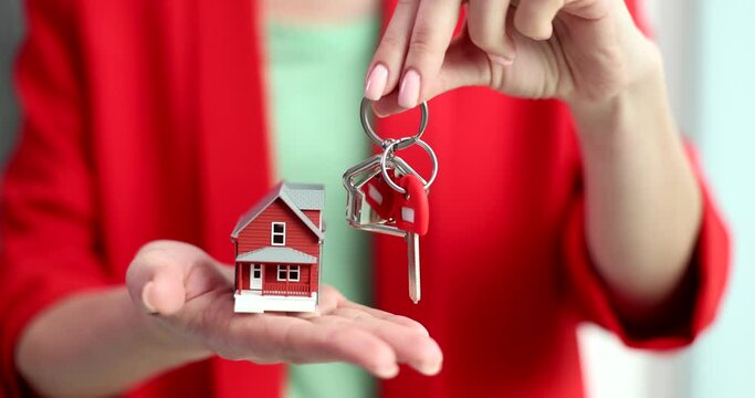 Key and house model in hands of female manager