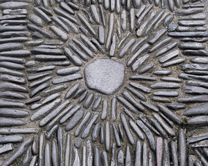Sunburst design with stones in concrete wall texture