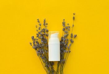 Flat lay organic lavender flowers, moisturizer cream on yellow background. The concept of beauty and wellness. Skincare and body