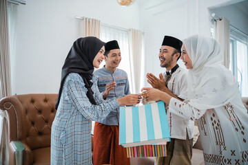 Two Muslim couples apologize to each other while celebrating Eid at home in the living room