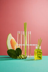 Front view of slices pink pomelo, green leaves, fresh lemongrass and glass bottle of lemongrass...