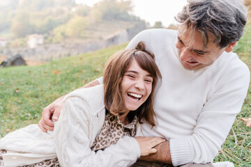 Fototapeta premium Italian man with gray hair and teenage daughter on the grass