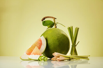 Bunches of lemongrass and pink pomelo (Citrus maxima) slices decorated on minimalist light...