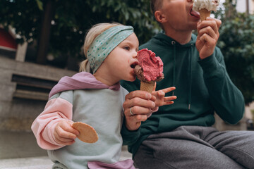 Man and baby eating italian ice cream on the street