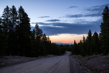 lonely dirt road at sunset in the mountains