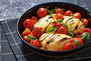 caprese chicken in black baking dish, top view