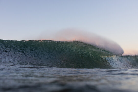 huge surfing wave breaking on a shallow reef in the ocean