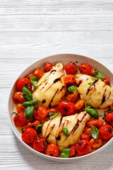 caprese chicken in white baking dish, top view