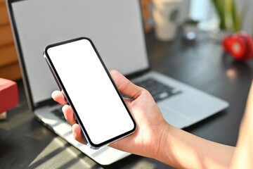 Woman hand holding mobile phone with white blank display, empty screen for graphic display montage