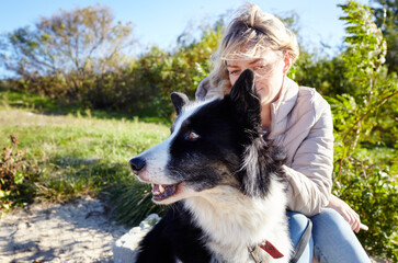 Owner with a siberian laika dog on a beach. Friendship of a dog and a woman