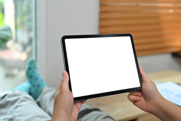 Close up view of woman using digital tablet in living room. Blank display for graphic display montage