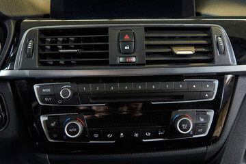 Fototapeta na wymiar car climate control unit and heated seats. deflectors of the car ventilation system, door lock button and alarm