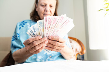 old women hands holding Turkish Lira banknotes  