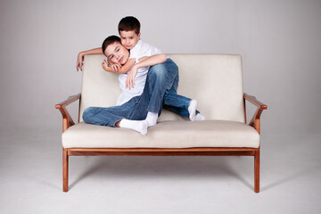 Fototapeta na wymiar Two boys sitting together in studio