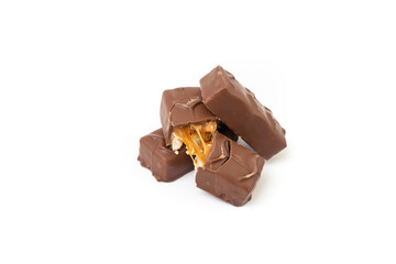 Hazelnuts and caramel cream chocolate bars stacked, isolated on white